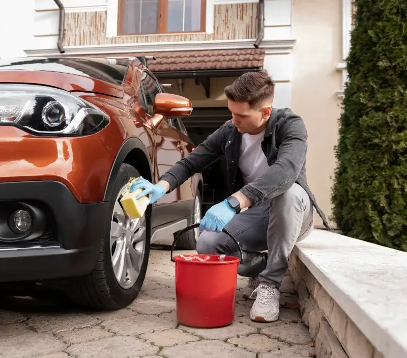 Lavage auto à domicile Les Junies : professionnel intervenant sur un véhicule